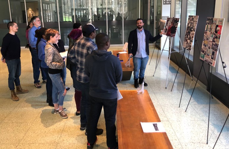 Postdoctoral Scholar Paolo Marinaro provides a tour of the art expo.
